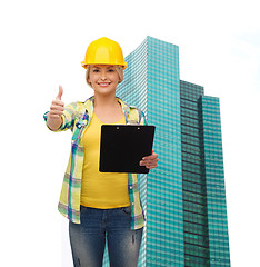 Image showing smiling woman in helmet with clipboard