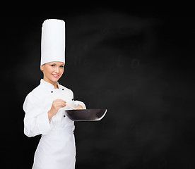 Image showing smiling female chef with pan and spoon