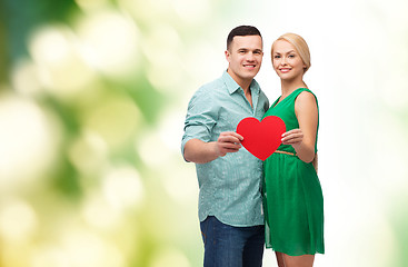 Image showing smiling couple holding big red heart