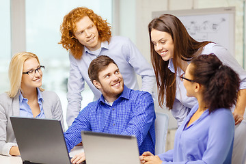 Image showing smiling team with laptop computers in office