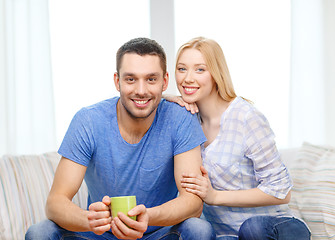 Image showing smiling man with cup of tea or coffee with wife