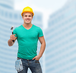 Image showing smiling manual worker in helmet with hammer