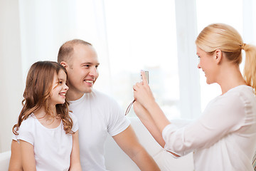 Image showing happy mother taking picture of father and daughter