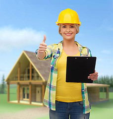 Image showing smiling woman in helmet with clipboard