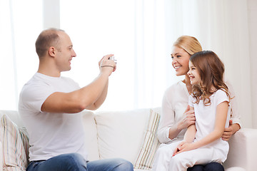 Image showing happy father taking picture of mother and daughter
