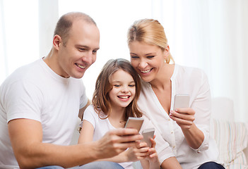 Image showing parents and little girl with smartphones at home