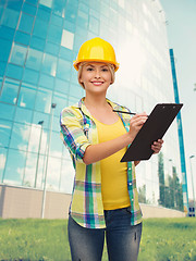 Image showing smiling woman in helmet with clipboard