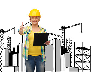 Image showing smiling woman in helmet with clipboard