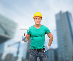 Image showing smiling manual worker in helmet with paint roller