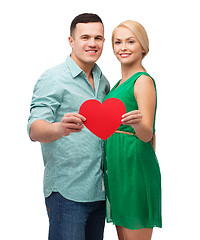 Image showing smiling couple holding big red heart