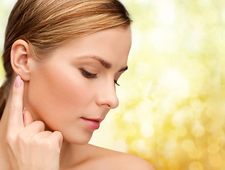 Image showing calm woman touching her ear