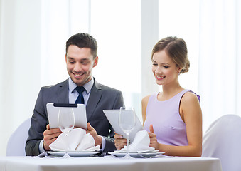 Image showing couple with menus on tablet pc at restaurant