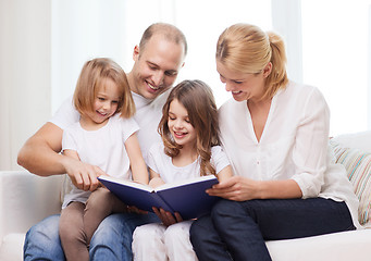 Image showing smiling family and two little girls with book