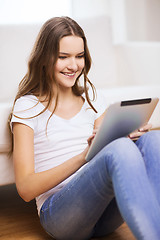 Image showing smiling teenage girl with tablet pc at home