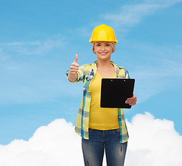 Image showing smiling woman in helmet with clipboard