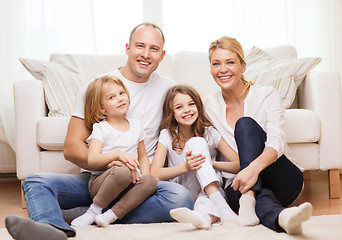 Image showing parents and two girls sitting on floor at home