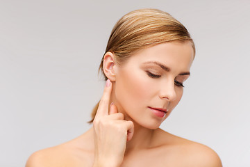 Image showing calm woman touching her ear