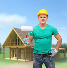 Image showing smiling manual worker in helmet with paint roller