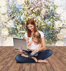 Image showing happy mother with adorable little girl and laptop