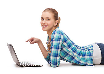 Image showing smiling woman with laptop and pointing finger