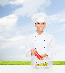 Image showing smiling female chef with preparing salad