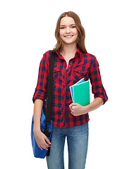 Image showing smiling female student with bag and notebooks