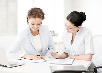 Image showing two smiling businesswomen working in office