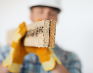 Image showing close up of male in gloves carrying wooden boards