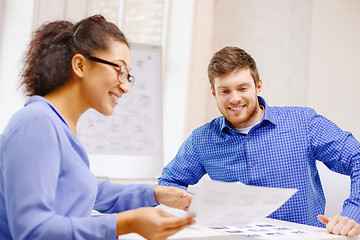 Image showing smiling team with paper at office