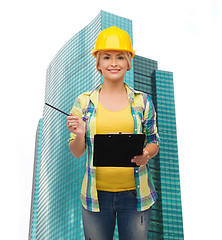 Image showing smiling woman in helmet with clipboard