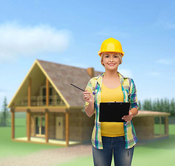 Image showing smiling woman in helmet with clipboard