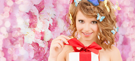 Image showing teenager with butterflies in hair opening present