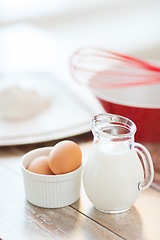 Image showing jugful of milk, eggs in a bowl and flour