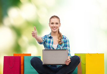 Image showing smiling girl with laptop comuter and shopping bags