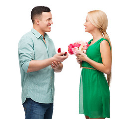 Image showing smiling couple with flower bouquet and ring