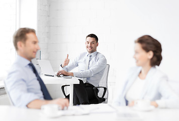 Image showing happy businessman showing thumbs up in office