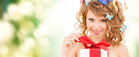 Image showing teenager with butterflies in hair opening present