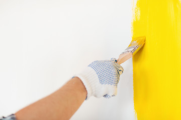 Image showing close up of male in gloves holding paintbrush