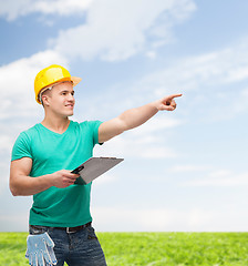 Image showing smiling man in helmet with clipboard