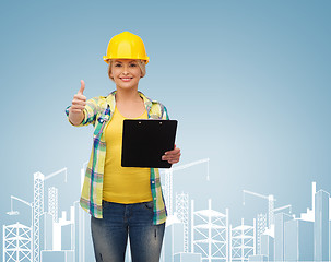 Image showing smiling woman in helmet with clipboard