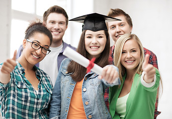 Image showing girl in graduation cap with diploma and students