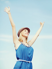 Image showing girl with hands up on the beach