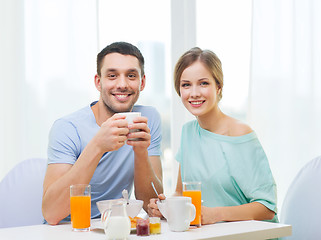 Image showing smiling couple having breakfast at home