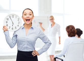 Image showing attractive businesswoman with wall clock