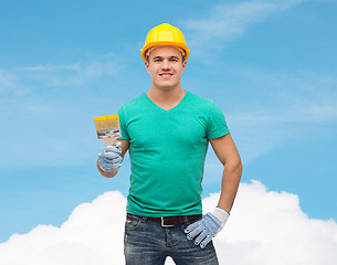 Image showing smiling manual worker in helmet with paintbrush