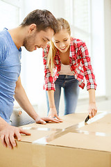 Image showing smiling couple opening big cardboard box