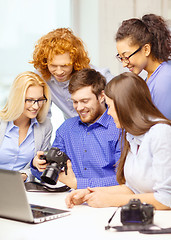 Image showing smiling team with laptop and photocamera in office