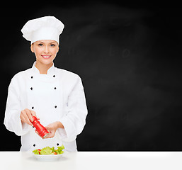 Image showing smiling female chef with preparing salad