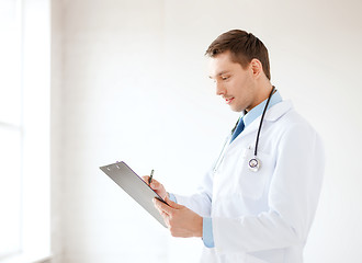 Image showing smiling male doctor with stethoscope and clipboard