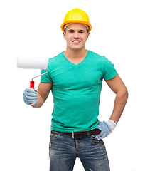 Image showing smiling manual worker in helmet with paint roller